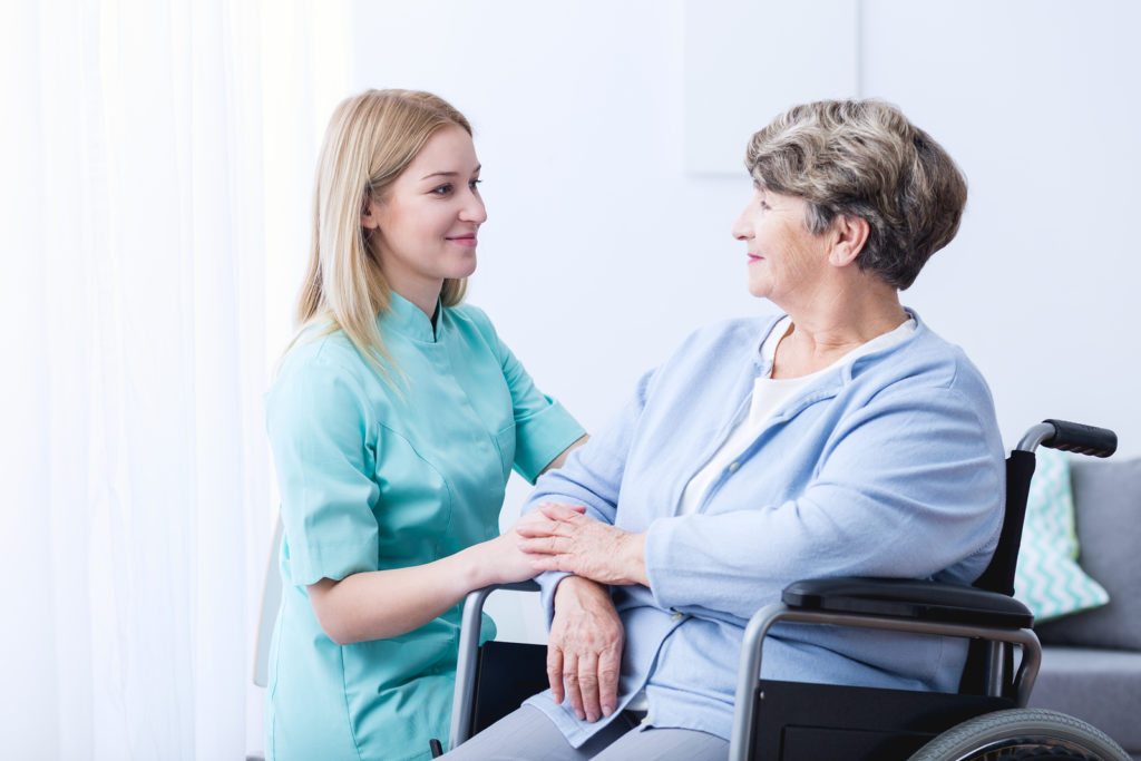 Nurse caring about elder woman at home